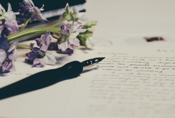 Start writing your cornerstone content that Google will love. pen paper and flowers