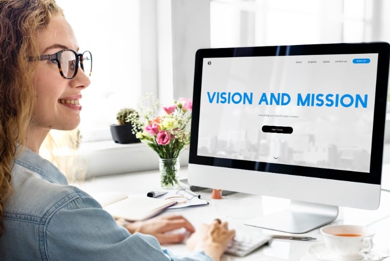 Woman at a computer saying mission and vision