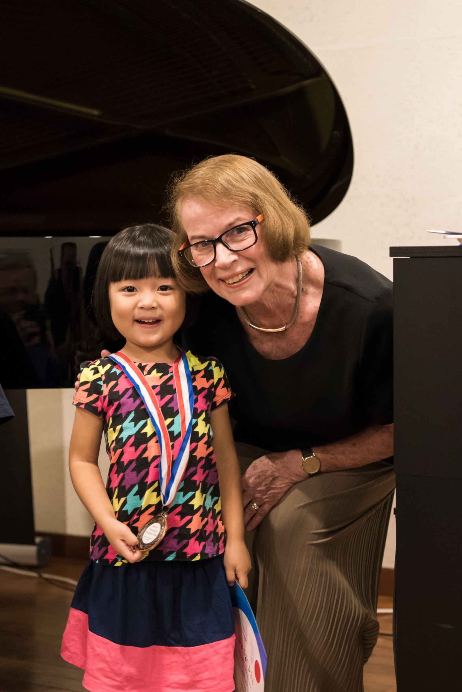 A participant receiving her medal and certificate from Morna Robinson and Mark Gibson 