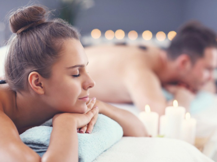 a man and a woman laying down in a spa