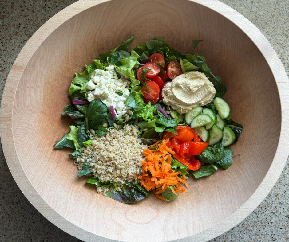 Mediterranean hummus garden salad with quinoa, fresh vegetables, and balsamic drizzle