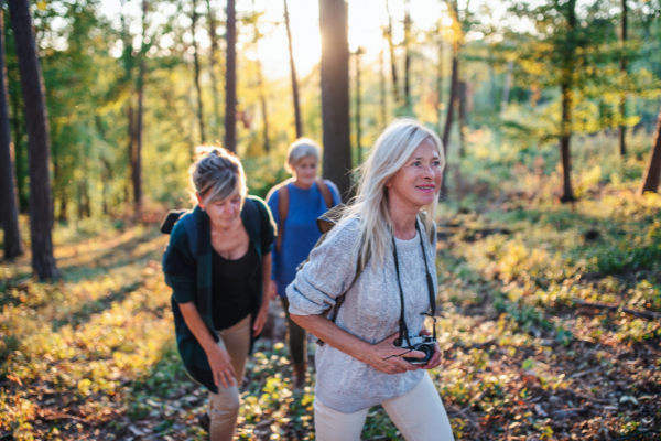 three middle age women walking in the woods