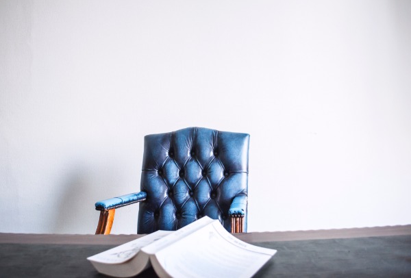 empty chair at a desk, book open to a page