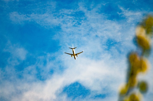 Airplane in blue sky. You can take vacations without emergency calls from co-workers.