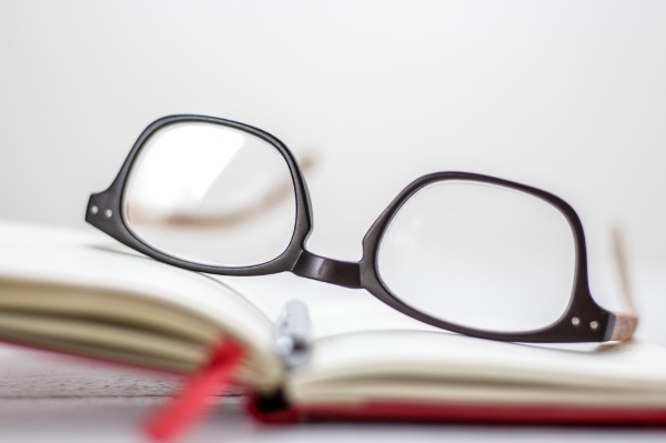 Eyeglasses on a book. Examine your options and understand that corporate jobs may not be secure. Be your own boss.