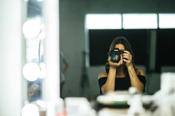 Woman taking a picture of herself in a mirror. Review what you've learned in life and share with others in similar circumstances.