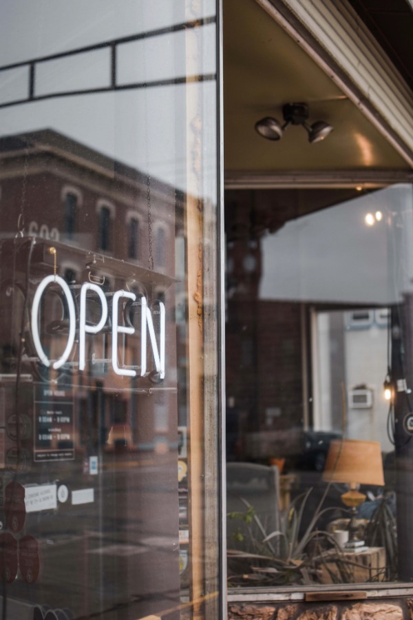 Business with a sign showing it is open. Renee Shupe opened her business and shares details on the Free At 50 blog.