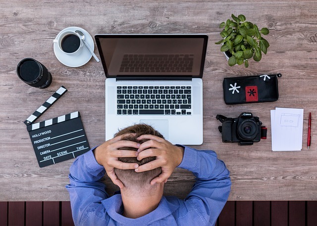 man in front of his laptop frustrated. writer's block is a real issue for everyone working to build a business online