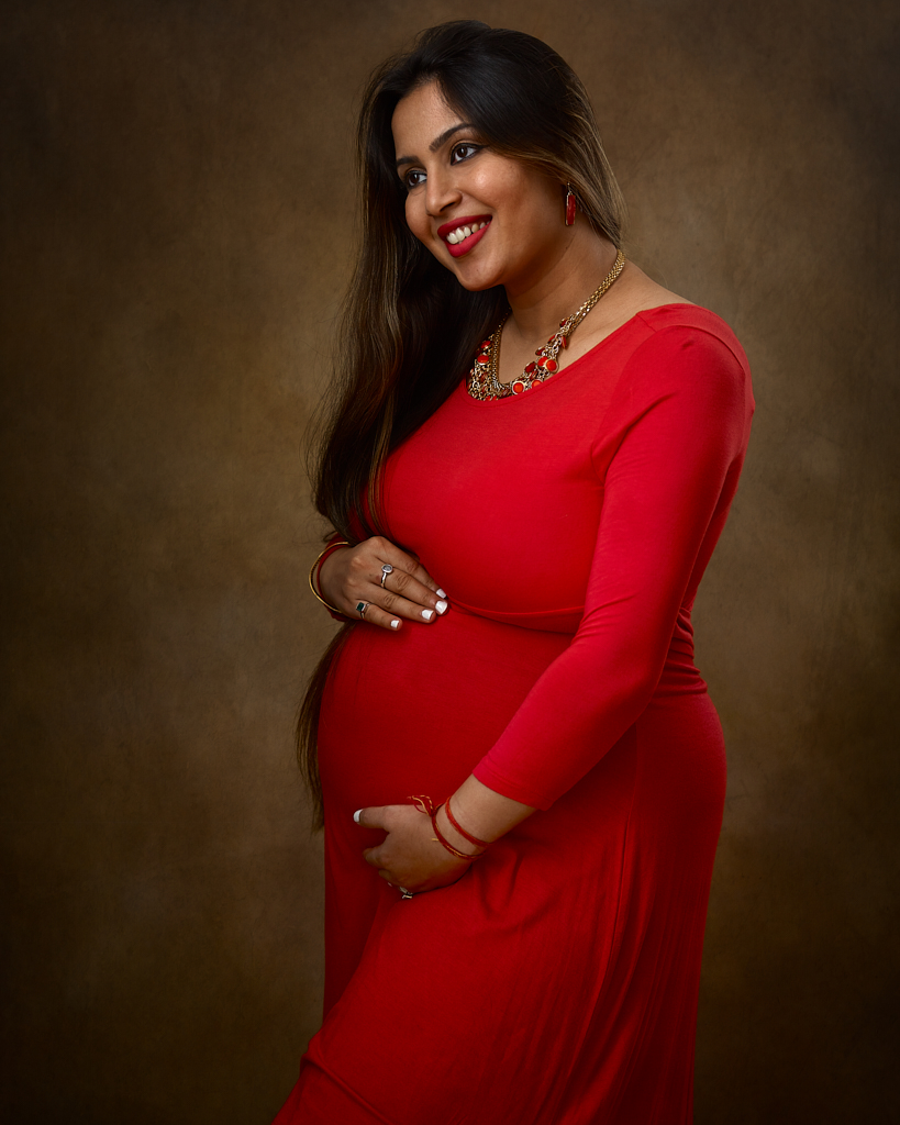 Maternity portrait of pregnant indian desi woman in pink maternity gown. Maternity portrait photographer near Washington DC  Portraits by Jared Wolfe in Alexandria VA