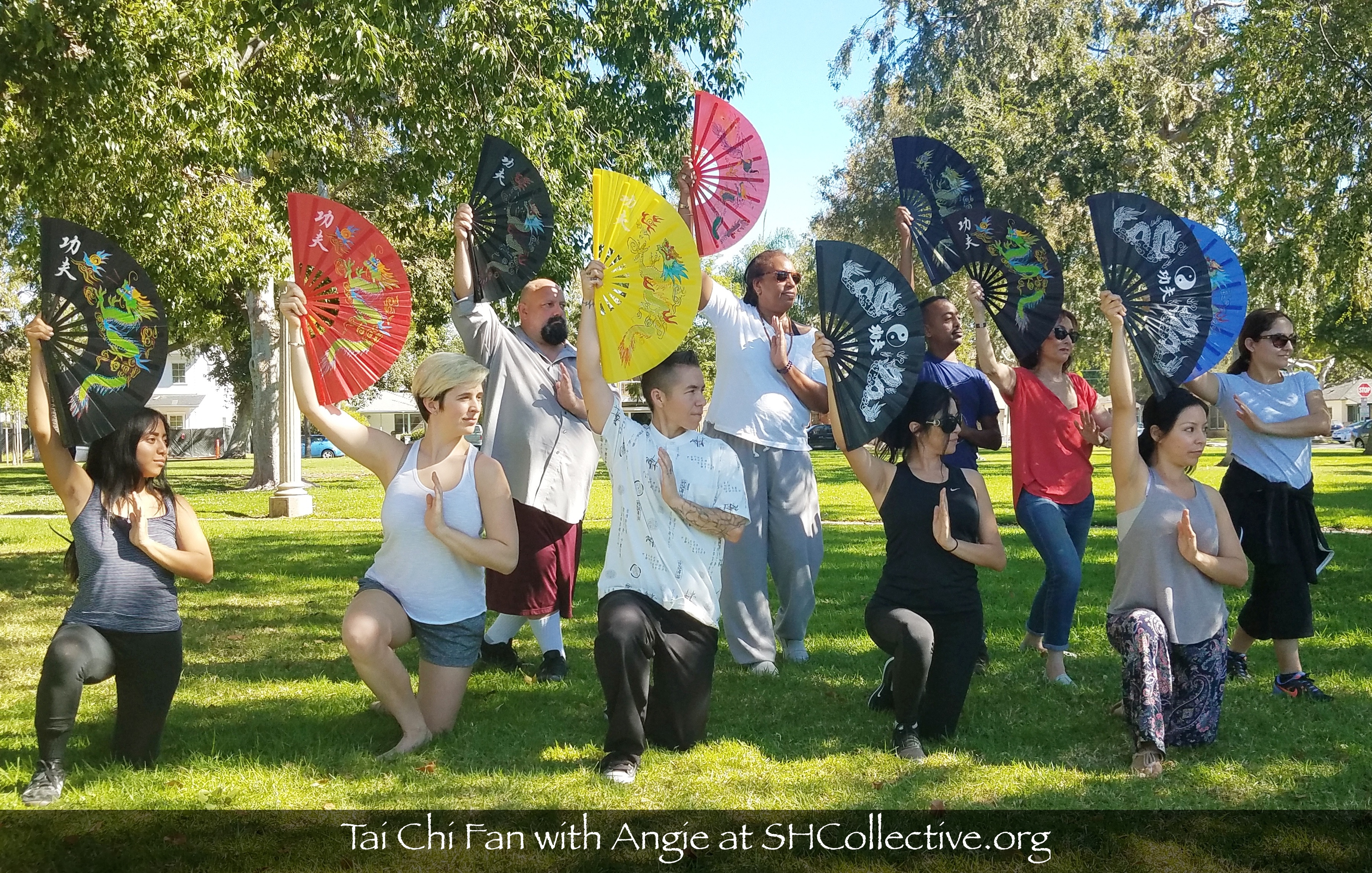 tai chi instructor Angie Sierra with her students holding tai chi fans looking to the left and posing 